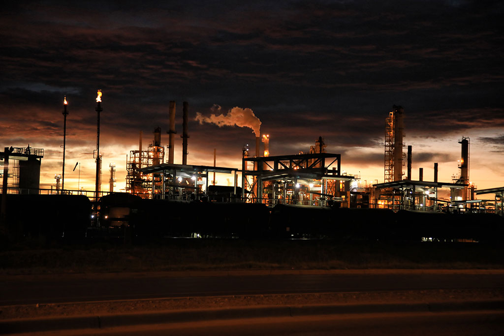 Oil refinery at night with flames and smoke