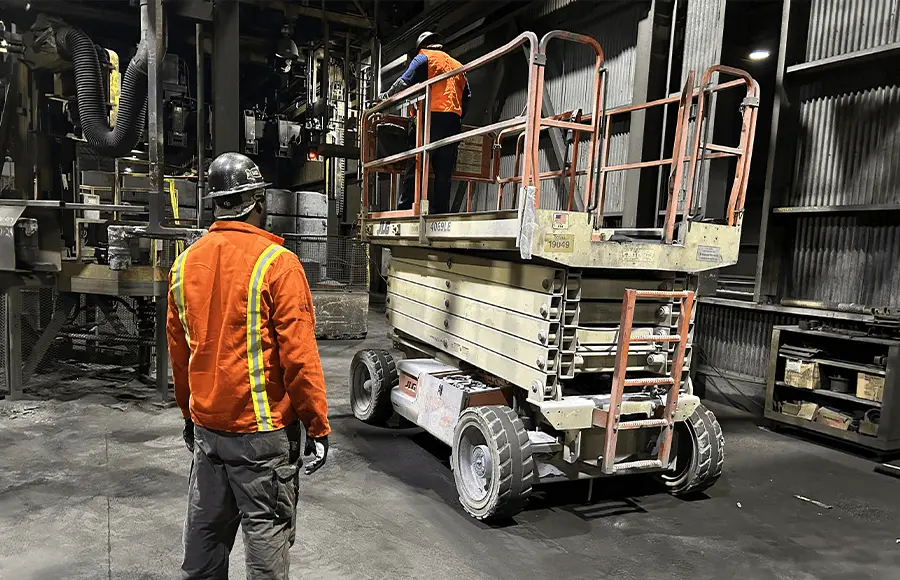 Worker operating scissor lift in Industry